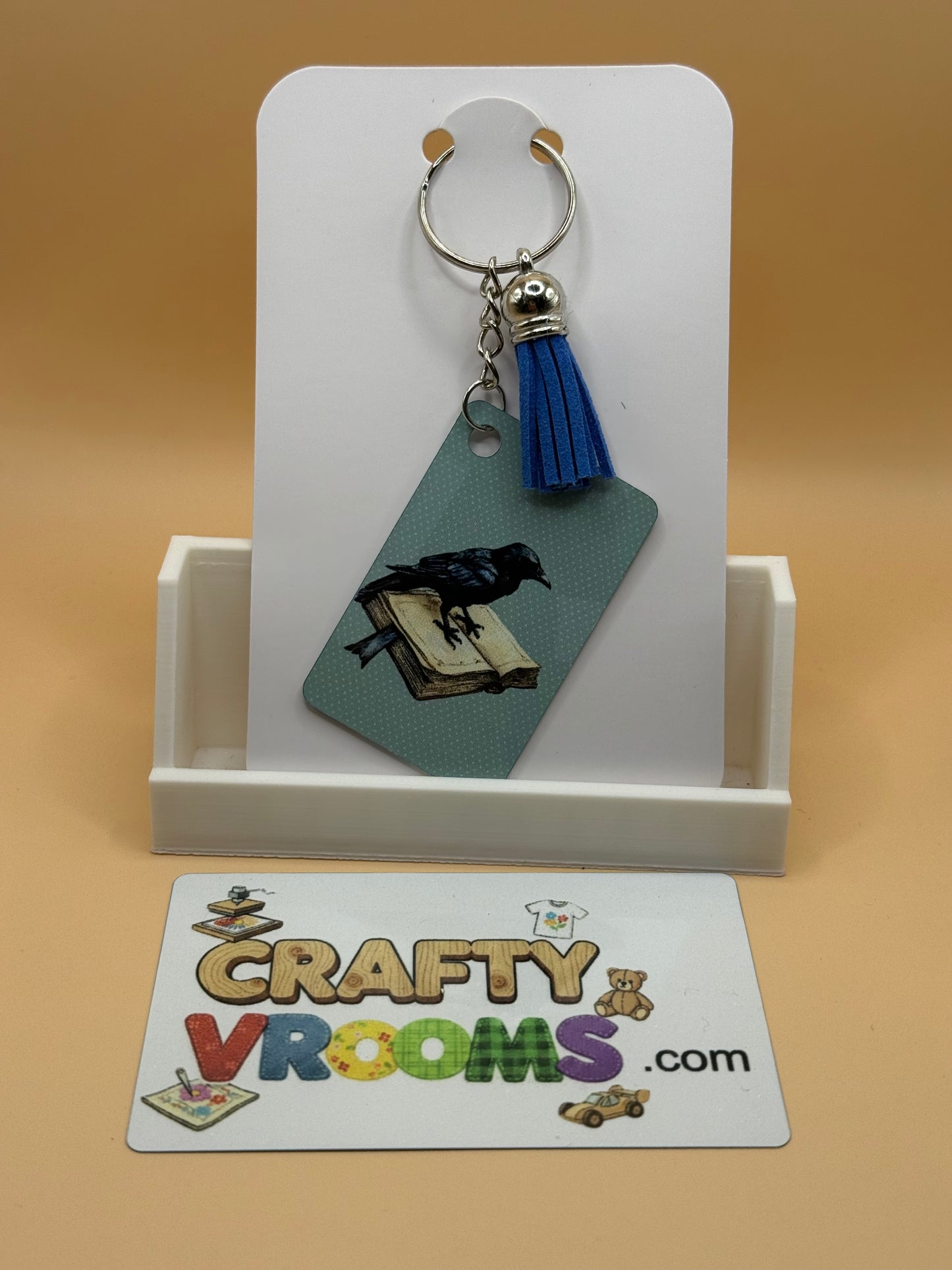 Rectangle keychain w/tassel - Academia Crow
